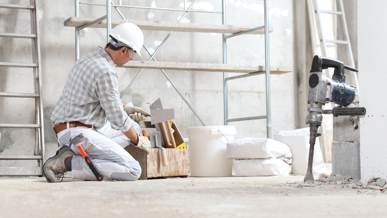Meseriaș care pregătește suprafețele și alege adezivii pentru construcții necesari unei lucrări de montaj