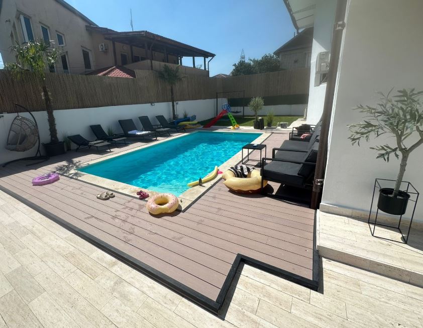 piscina de dimensiuni mici, care e frumos incadrata de un deck wpc