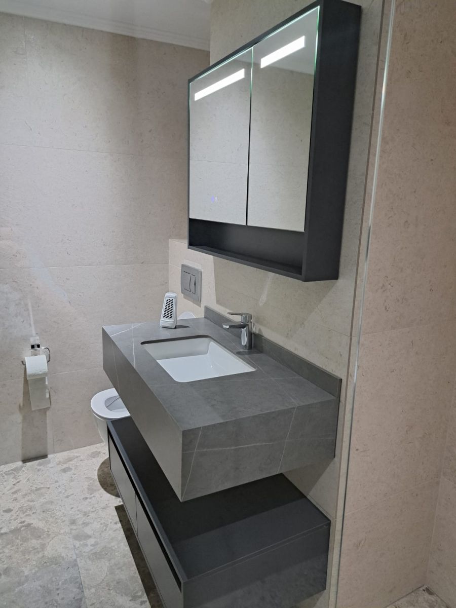 Baie premium cu mobilier suspendat și oglindă iluminată LED, într-un proiect de renovare completă realizat de Total Design.