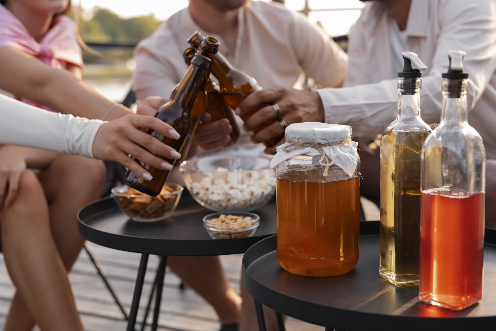 Grup de prieteni la o petrecere relaxată, savurând băuturi nonalcoolice, kombucha și alternative moderne la alcool.