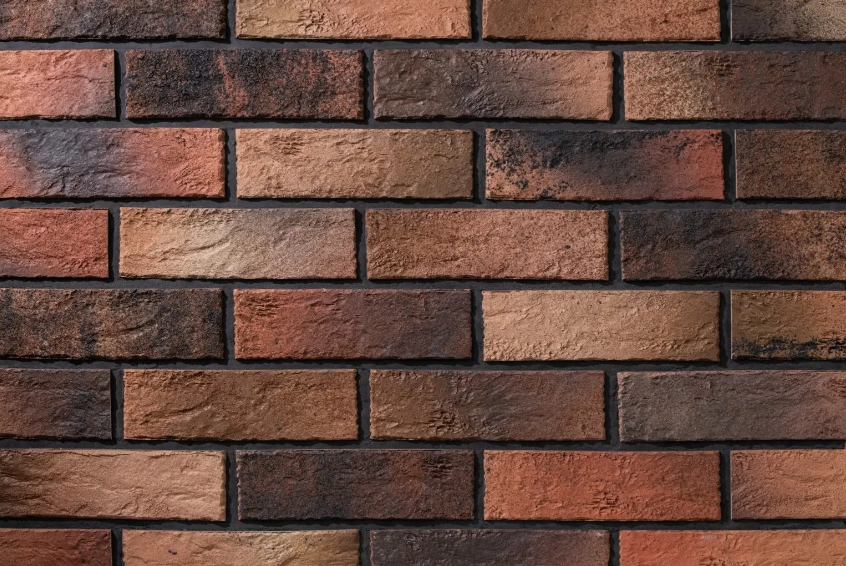Cărămidă aparentă ceramică în nuanțe rustice, folosită ca finisaj pentru fațade, socluri și zone de accent într-o casă durabilă.