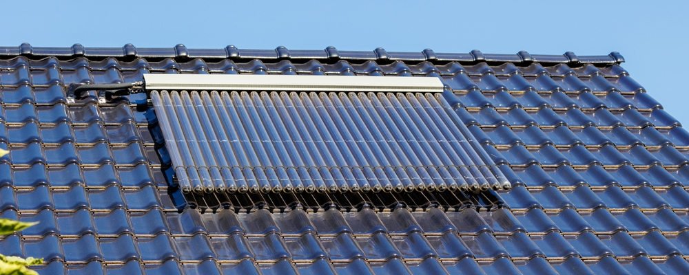 Colectoare solare montate pe acoperișul unei locuințe noi pentru producerea apei calde menajere cu energie solară.