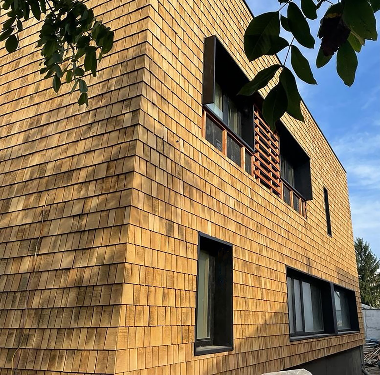 Fațadă ventilată din șindrilă de stejar șlefuită Octogonal Plus Georoof la o casă cu arhitectură contemporană