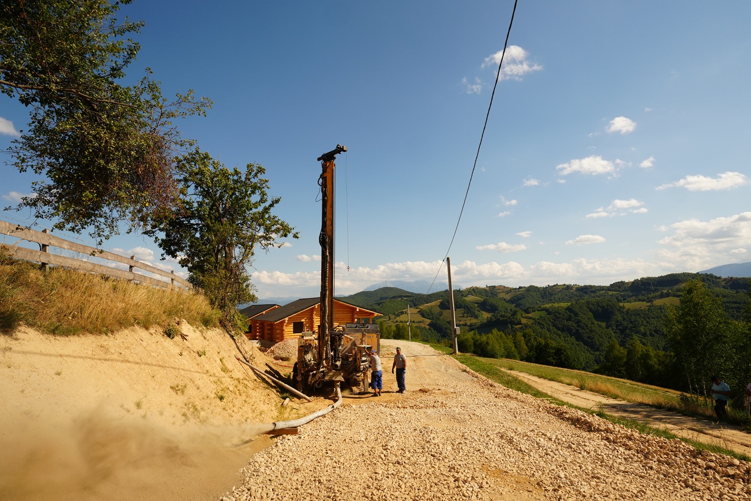 Utilaj de foraj apă în construcții, amplasat pe teren în pantă, pentru realizarea unui puț de apă rezidențial cu tehnologie ciocan de fund.