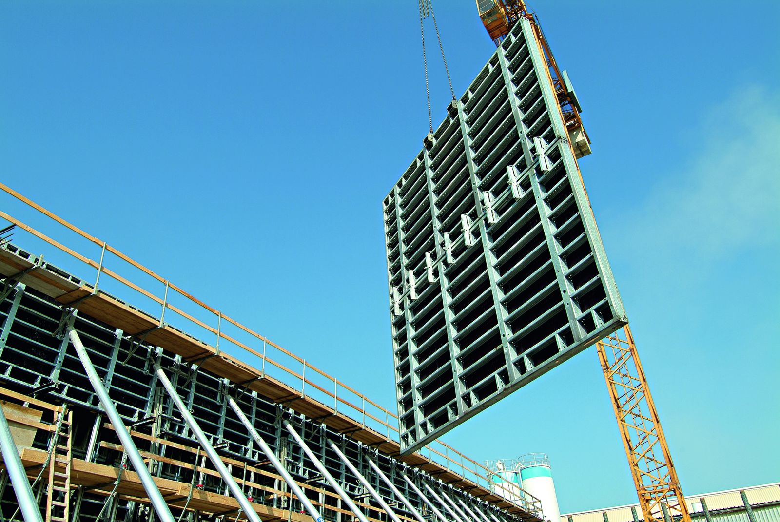 Sistem modular Hünnebeck de cofraje pentru pereți, ridicat cu macaraua pe șantier