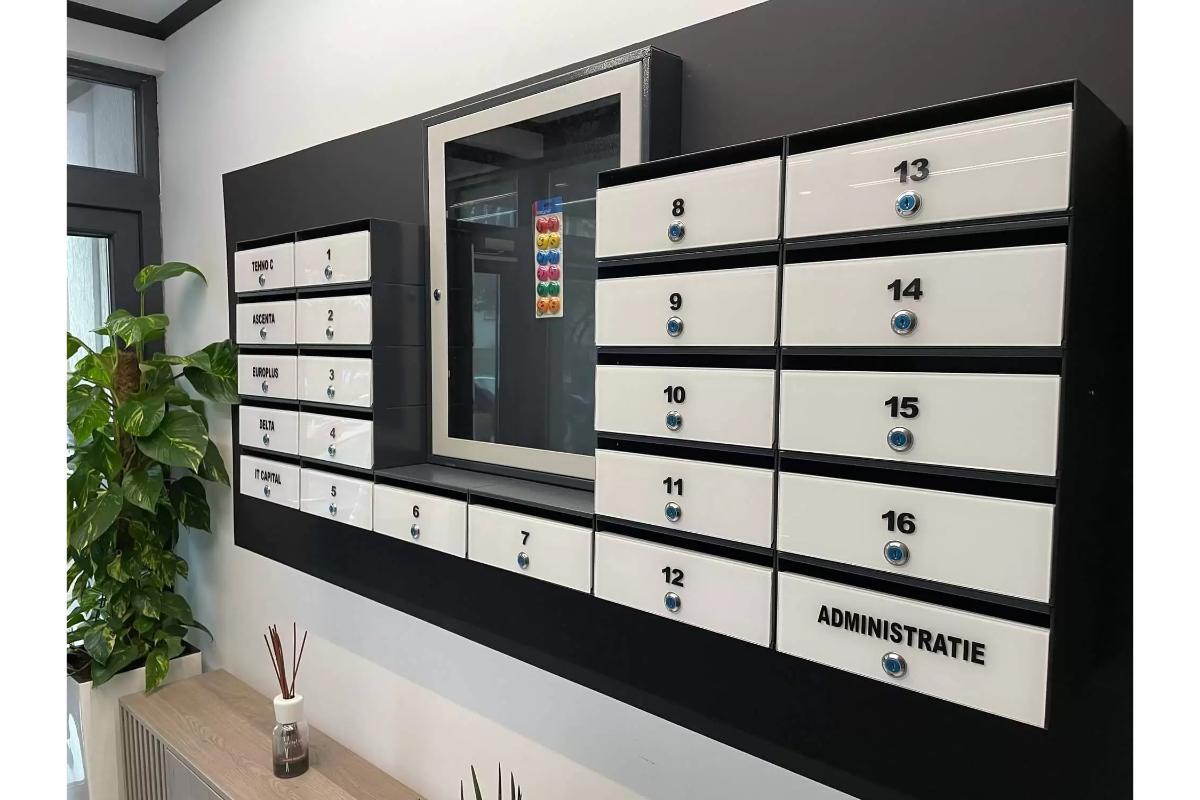 Ansamblu de cutii poștale moderne pentru bloc, integrate lângă avizier și panou administrativ într-un spațiu comun elegant.