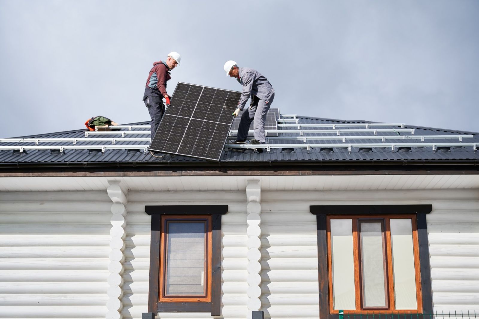 Echipă specializată în montajul panourilor fotovoltaice pe acoperișul unei case