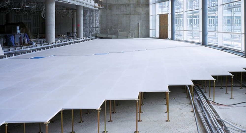 Pardoseală tehnologică supraînălțată montată într-un spațiu comercial modern, cu acces la infrastructura de cabluri și instalații