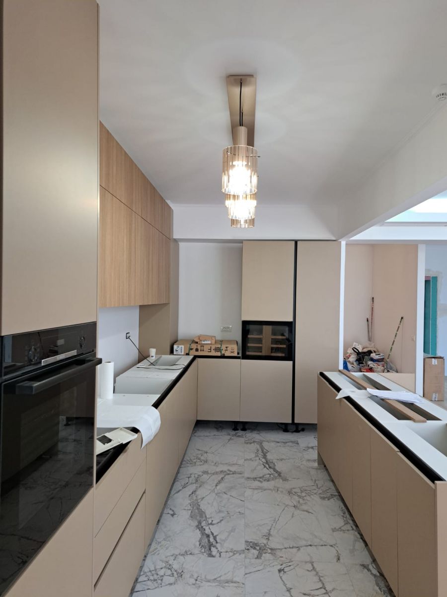 Renovare completă apartament în București realizată de Total Design, cu bucătărie modernă open-space și insulă centrală.