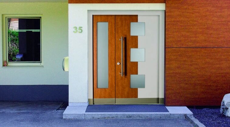 Ușă de exterior din lemn stratificat, cu design modern, montată la intrarea unei case contemporane.